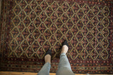 A personal, top-down view of the antique Malayer's intricate lattice and floral design.