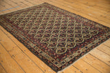 Angled view of an antique Malayer rug, showcasing the allover floral lattice pattern and rich color saturation.