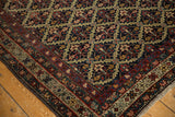 Corner detail of an antique Malayer rug with an intricate floral lattice and wine red border.