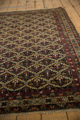 Perspective view of the intricate floral lattice and fine weave on an antique Persian Malayer rug.
