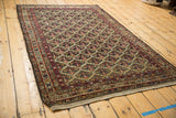 Angled view of an antique Malayer rug highlighting the intricate allover lattice pattern and detailed borders.
