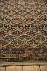 Angled view revealing the intricate lattice weave and low pile of an antique Malayer rug.
