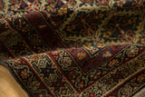 Dense, even pile and fine floral detailing on a folded antique Persian Malayer rug.