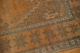 Distressed Oushak rug corner: copper terra cotta and dark starburst band, geometric border.
