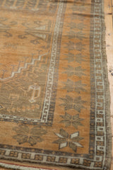 Distressed texture of copper terra cotta Oushak rug, showing geometric and starburst border.