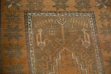 Distressed texture on vintage Oushak rug showing copper, olive, and ivory geometric starburst motifs.