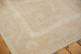 Vintage Distressed Oushak carpet corner displaying low pile, subtle ivory pattern, and secured edge.