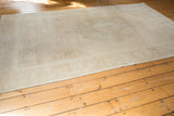 Close-up of the distressed Oushak rug's ivory and beige low pile edge.