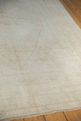 Distressed Oushak carpet close-up, revealing low pile texture and subtle, faded germinating seed motif.