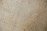 Subtle ivory, silver, and beige patterns on the low pile of a distressed Oushak rug.