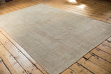 Distressed pile and intricate outlined border of the vintage Oushak rug corner.
