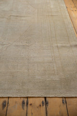 Angled detail of the vintage distressed Oushak carpet, showcasing its low pile and subtle intricate patterns.