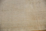 Close-up of the distressed vintage Oushak rug's even low pile, with subtle beige and ivory tones.