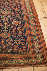 Antique Serbend rug's intricate splayed floral vinery on navy, framed by rich terracotta borders.