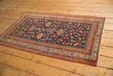 Corner of Antique Serbend rug with navy field, terra cotta borders, splayed floral vinery.