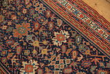 Antique Serbend rug's rich navy field with splayed floral, boteh motifs, and patterned border.