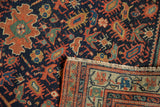 Antique Serbend rug detail: navy, terracotta splayed floral pile, showing fringe and patterned reverse.