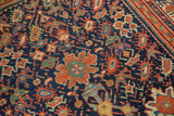 Saturated navy field of antique Serbend rug, showing splayed floral motifs and botehs.