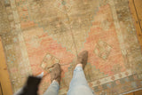 Vintage distressed Oushak rug with abrashed blush, bronze, and blue geometric floral motifs.