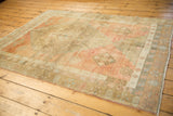 Heavily abrashed field and geometric motifs in blush, pale bronze, and powder blue.