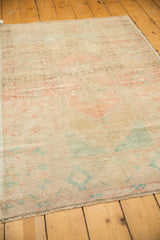 Texture of distressed Oushak rug with even wear, featuring blush, seafoam, sand colors, and fringe.