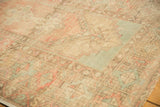 Distressed Oushak rug showcasing faded blush, seafoam, and sand geometric border details.