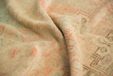 Distressed Oushak rug pile with even wear, in soft blush, sand, and pale green.