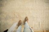 The even low pile and tone-on-tone pattern of a distressed Oushak rug viewed from above.