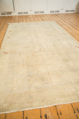 Vintage distressed Oushak carpet viewed lengthwise, showing its low pile and muted tone-on-tone field.