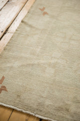 Hand-knotted low pile texture on a distressed Oushak carpet with a sparse copper pinwheel motif.