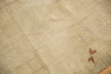 Even low pile and knot heads of a distressed Oushak rug, showing a small copper pinwheel design element.