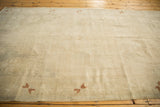 An Oushak carpet's antique ivory field and low pile texture, with sparse copper pinwheel motifs.