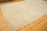 A corner of the distressed Oushak carpet showing its even, low pile and secured side edge.