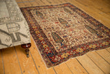 Antique Persian Afshar rug corner featuring ivory tree-of-life pattern and multi-hued brick red borders.