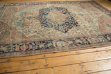 Antique Farahan Sarouk rug's outer minor border with intricate navy and pale terra cotta floral patterns.
