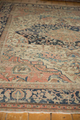 Intricate floral vinery on antique Farahan Sarouk showing navy, ivory, blush, and visible foundation wear.