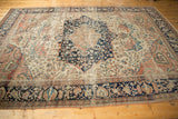 Collector antique Farahan Sarouk rug: prominent navy medallion, intricate ivory floral field, and soft abrash.