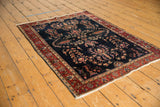 Antique Mohajeran Sarouk rug's deep navy field, bursting floral motifs, and unique palmette border.