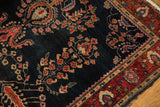Antique Mohajeran Sarouk rug corner, showcasing wine red palmette border and navy floral field.