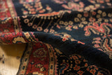Antique Mohajeran Sarouk rug's deep navy field, blush florals, and plush, even pile texture.