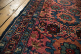 Lilihan rug detail: dark blue border, raspberry field with vinery, visible foundation.
