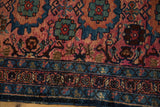 Close-up of vintage Lilihan runner with dusty raspberry field, sky blue florals, and deep blue border.