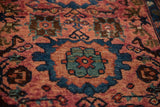 Vintage Persian Lilihan rug's dusty raspberry ground with blue and green oversized floral and vine motifs.