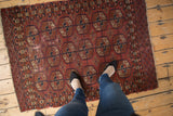 Vintage Turkmen rug featuring madder red and navy blue geometric 'elephant footprint' gul motif.