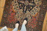 Antique Persian Farahan Sarouk, showing bold navy medallion, delicate vinery, and even pile wear.