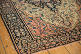 Antique Farahan Sarouk rug's dark navy palmette border and blush field vinery.