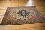 Antique Farahan Sarouk rug corner, dark navy palmette border with blush, ivory vinery.