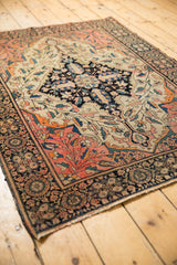 Antique Farahan Sarouk rug: bold navy roundel medallion, ivory vinery, and blush palmette border.