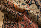 Detailed fold of the antique Farahan Sarouk rug showing navy, blush, ivory palmette border and vinery.