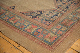 Close-up of antique Serab rug corner with blush, sky blue, and navy geometric Herati spandrel.
